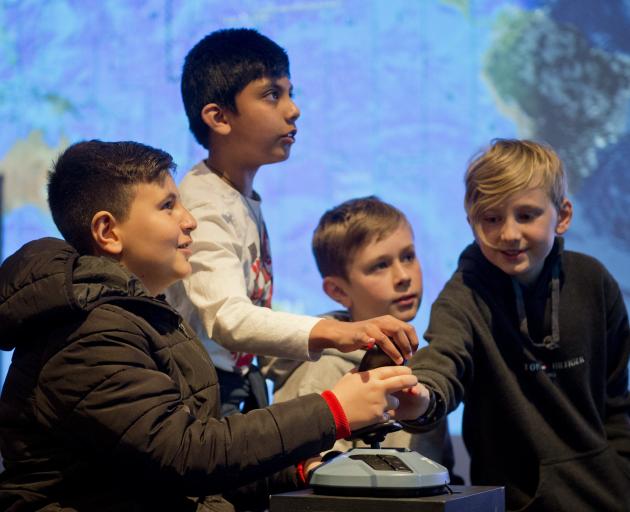 Flying a space shuttle at the Aotearoa in Space science showcase at Otago Museum are George...