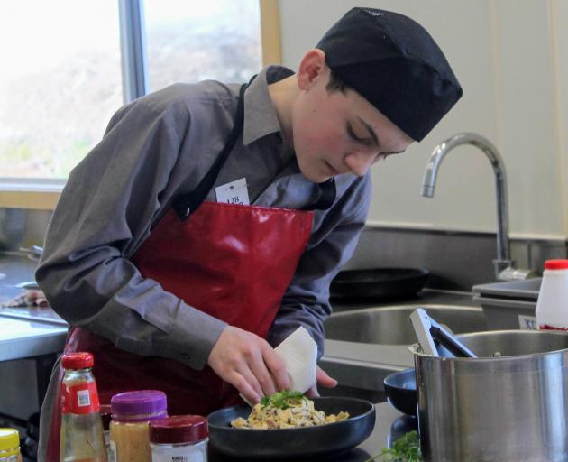 James Hargest College pupil Logan Jordan (13) adds the final touches to his version of fettuccine...