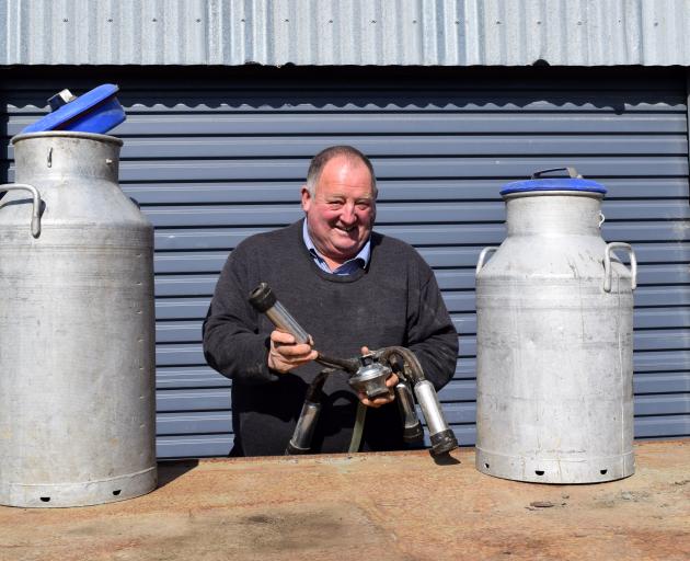 Green Island Bush Farms owner Ross Smaill shows aluminium milk cans and a milking cluster on...