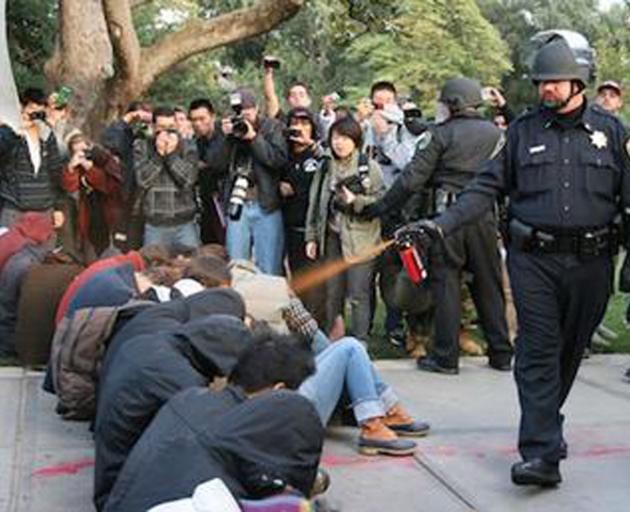 A police officer fires Sabre Red Mk-9 pepper spray at University of California Davis student...