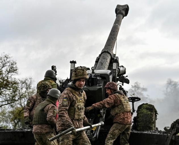 Ukrainian service members fire a shell from a howitzer along the front line in Zaporizhzhia...