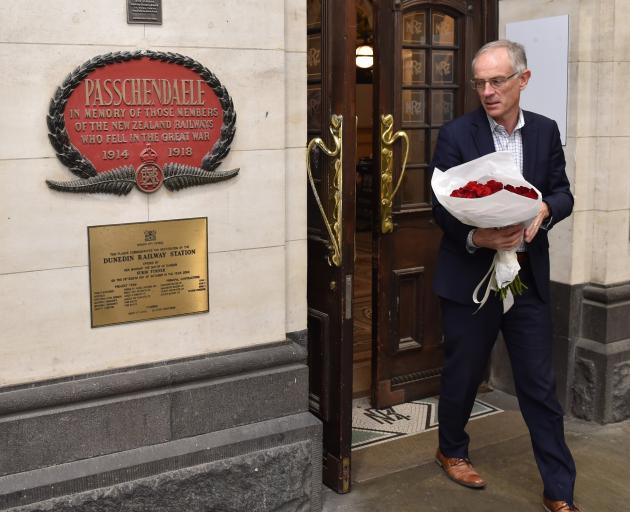 Anderson Lloyd partner Frazer Barton prepares to lay 30 roses at the Dunedin Railway Station...