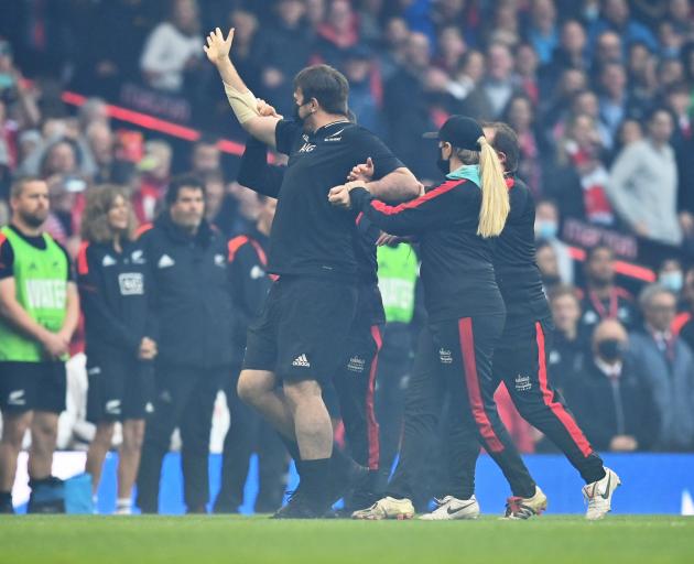 Pitch invader Daniel Jarvis is removed from the field after lining up with the All Blacks for the...