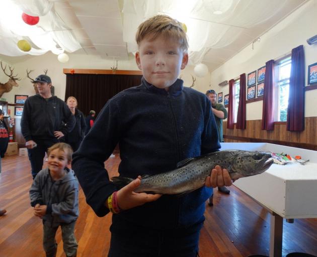 Holding his catch of the day, Sean Clark (11) shows off a good-sized brown trout.
