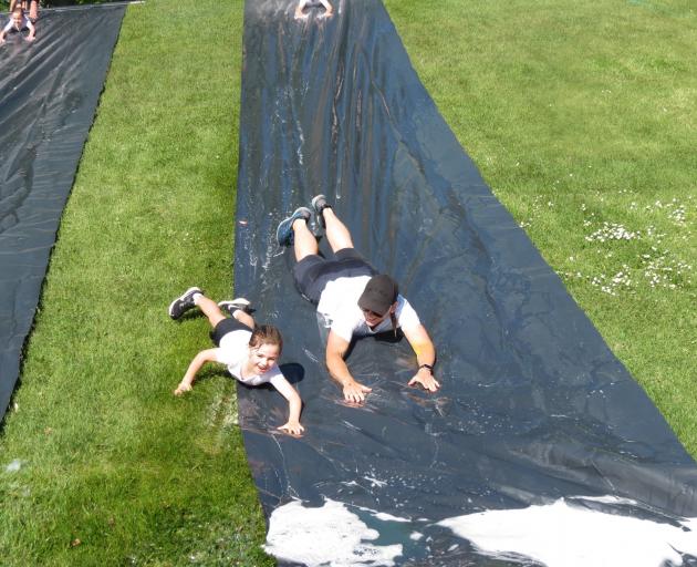 Mother-daughter duo Lanee and Ruby (9) Harkness slither down the water slide.