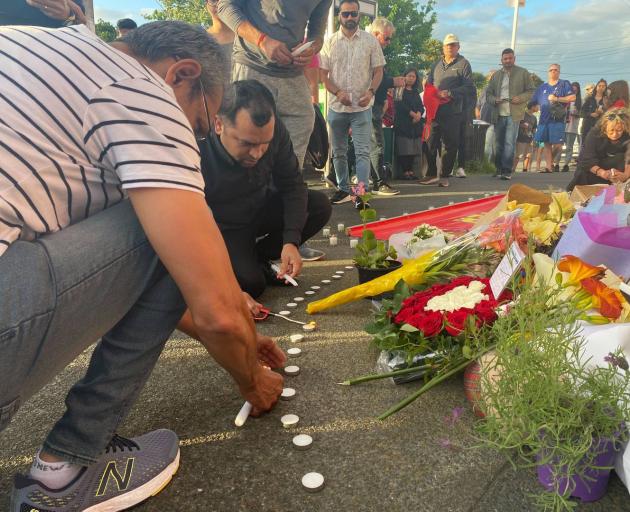 Mourners light candles in memory of slain dairy worker Janak Patel last night. Photo: NZ Herald 