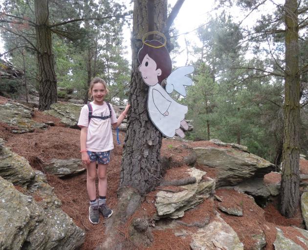 Ellie Lanham rests beside an angel character on the Christmas trail at Half Mile Reserve on...