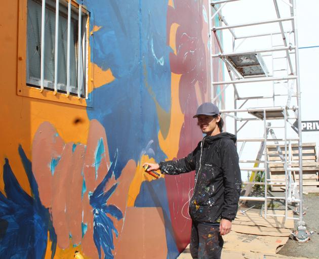 Street artist Koryu Aoshima works on his mural inspired by Roman goddess Minerva near Centre...