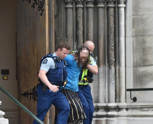 Police officers remove a man from First Church in central Dunedin yesterday. PHOTO: GREGOR...