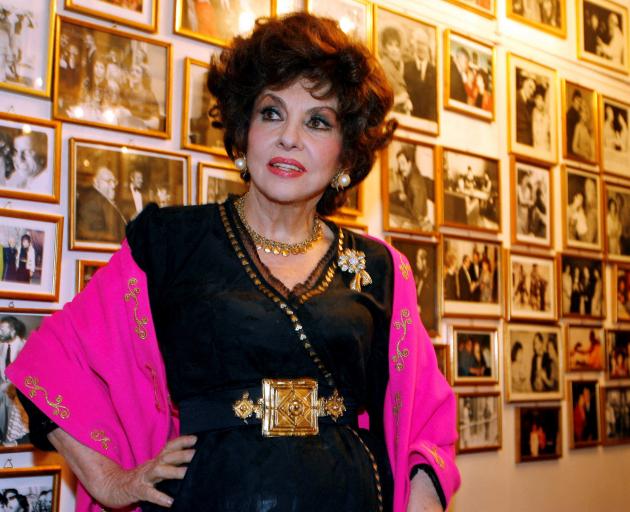 Gina Lollobrigida in front of a wall of celebrity photos in her villa in southern Rome. Photo:...