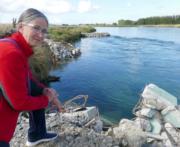 Concerned Balclutha resident Suzanne Schofield inspects rubble dumped in the Clutha River behind...