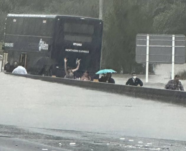 Bus passengers evacuate after their bus was stranded on Auckland's Northern motorway. Photo:...