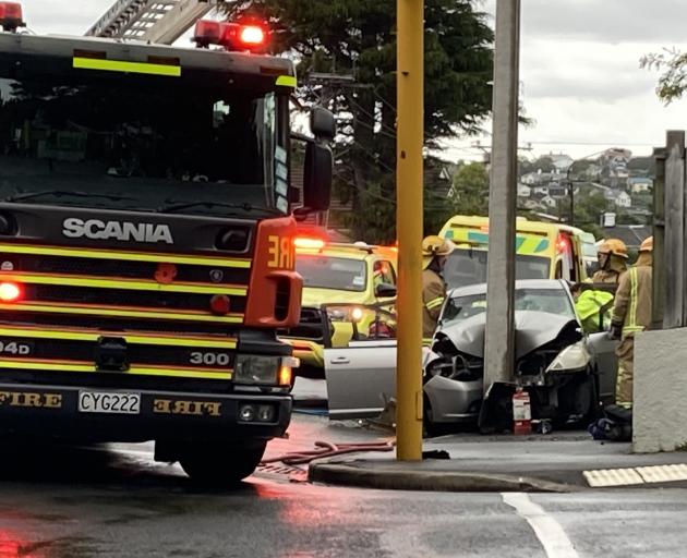 Emergency services work to free two people trapped in a car after it crashed into a pole at the...
