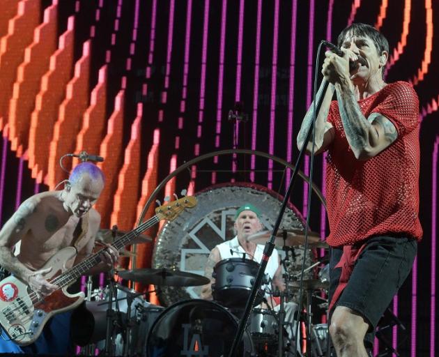 Members of Red Hot Chili Peppers (from left) Flea,  Chad Smith and Anthony Kiedis  perform in...