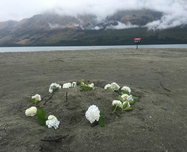 Flowers and official warning signs were placed at the lakefront this morning. Photo: Tracey...