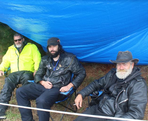 Taking shelter from the rain are (from left) Dennis Leveridge, Hamish Dow and Brian ‘‘Cowboy’’...