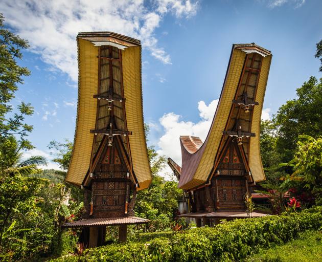 Intricately carved, elaborately painted, saddleback-roofed alang, or rice barns, stand proudly...