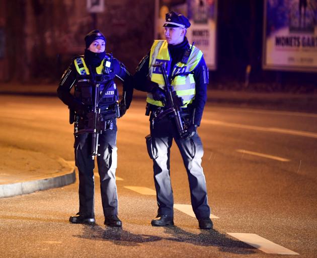 Police secure the area after at least six people were shot dead and several more injured in a...