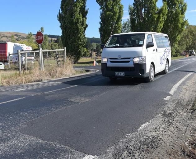 A Toyota Hiace van prepares to pass over a repaired pothole in Gladstone Rd near the intersection...