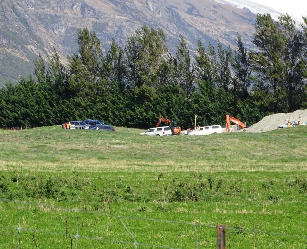 Police cars sit alongside utes and several diggers at the scene of a workplace death in Jacks...