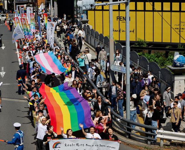 Participants march during the Tokyo Rainbow Pride parade, celebrating advances in LGBTQ rights...