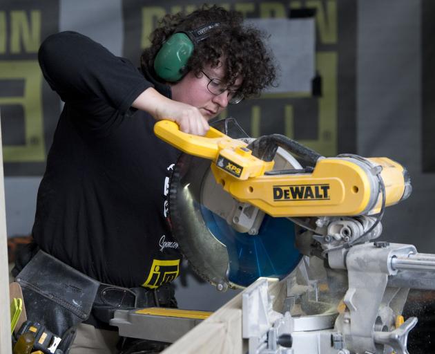 Third-year building apprentice Grace Auckram has her eyes on the prize while cutting a piece of...