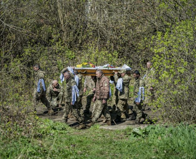 Ukrainian soldiers carry the coffin of a fellow soldier, killed during heavy fighting in the...