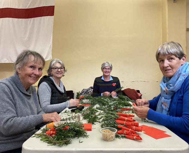 Working together at HMNZS Toroa on Monday to make some of the 4000-plus posies laid at the...