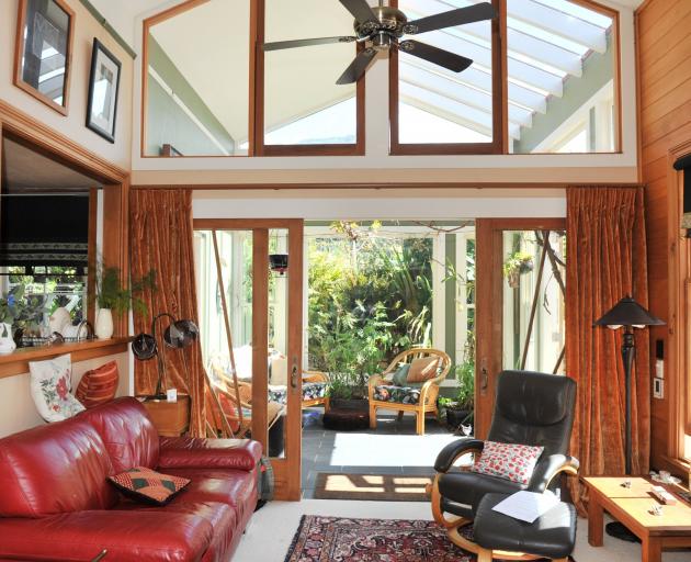 The living area has a raised ceiling and recycled sliding doors that lead into the conservatory.