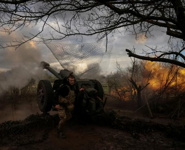 Ukrainian service members fire a howitzer at a front line, near the city of Bakhmut. Photo: Reuters