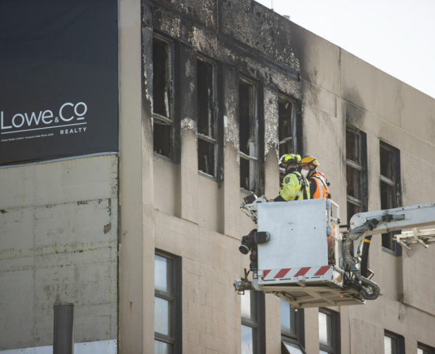Fire investigators assess the charred roof at the Loafers Lodge building this morning. Photo: NZ...