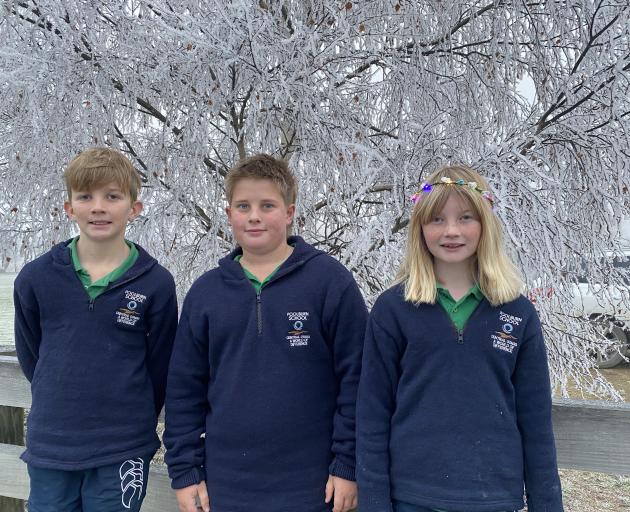 Poolburn Primary School pupils, from left, Cameron Gare, Charlie Heaps and Poppy Gare, stay warm...