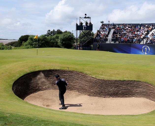Leader Brian Harman plays out of a bunker on the tricky par 3 17th. Photo: Getty Images