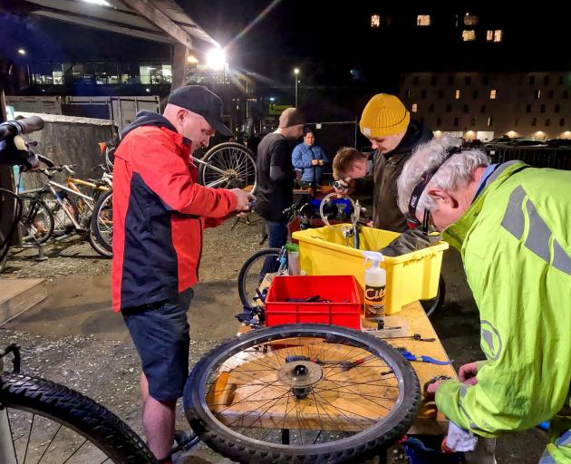 Volunteers work to get bikes ready for a recently-arrived refugee family. Photo: Geoff Sloan
