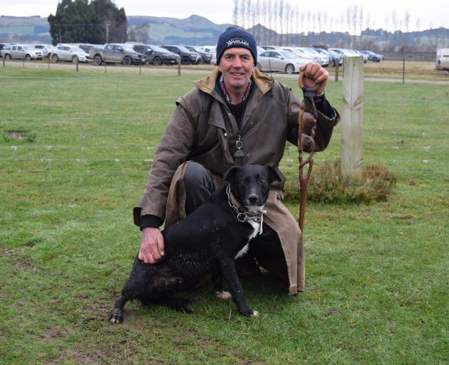 George Broughton pats heading dog Boss after selling him for $5000 at the Dog Sale in 2021.