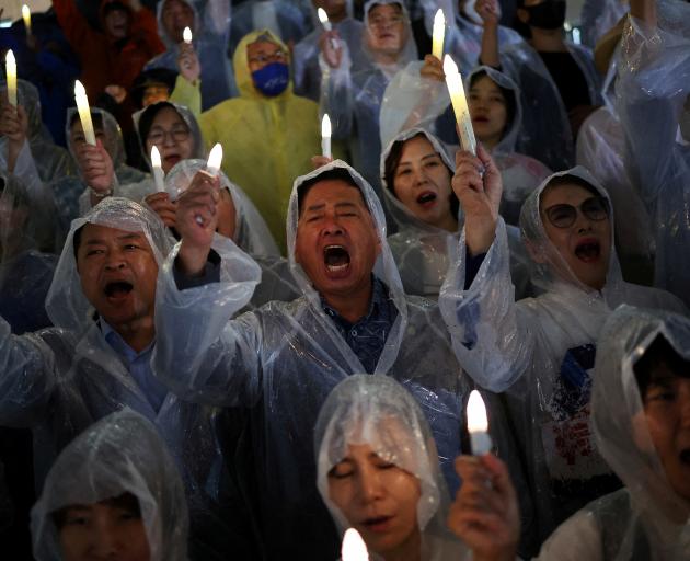 Members of South Korea's main opposition Democratic Party chant slogans during a candlelight...