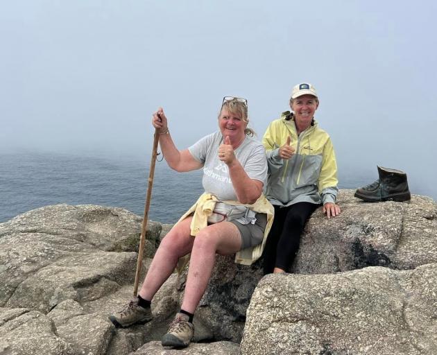 Cheryl Neill (left) and her sister Kim Van Gog take a break at Cape Finisterre, the end of their...