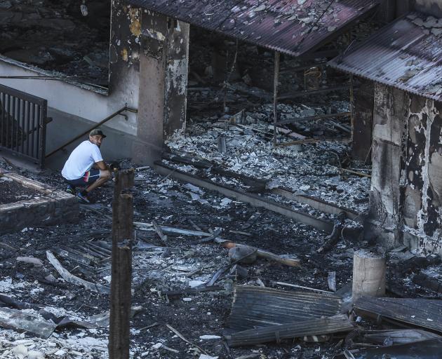 A man looks at the devastation wrought by the out of control wildfire in Lahaina. Photo: Getty...