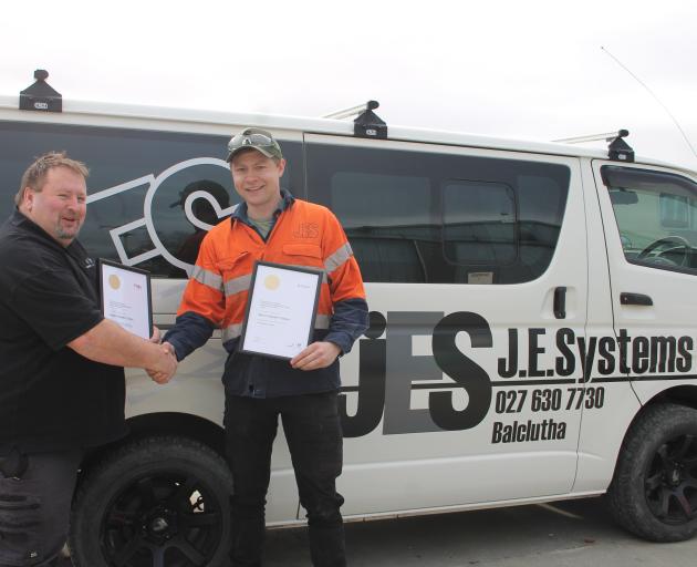 Competenz training adviser Stuart Hewson (left) hands over Balclutha man Aaron Taylor’s New...