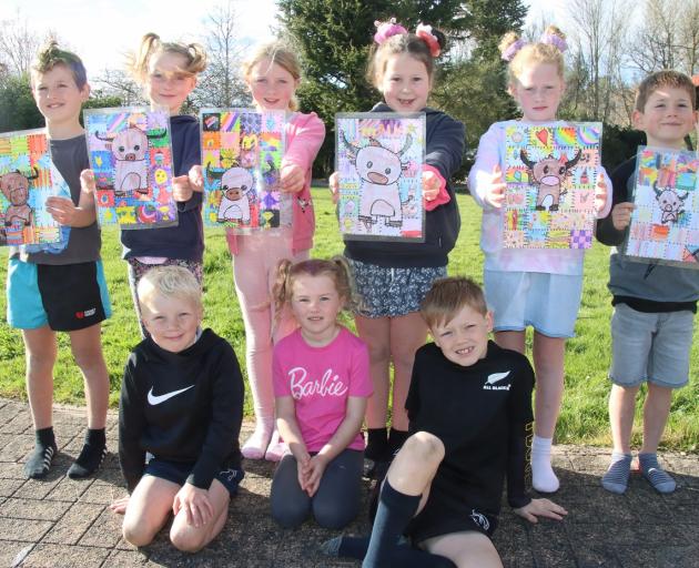 Waikoikoi School pupils hold the artworks they have made to illustrate The Patchwork Farmyard....