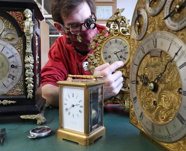 A clock conservation student  adjusts clocks in the clock conservation workshop at West Dean...
