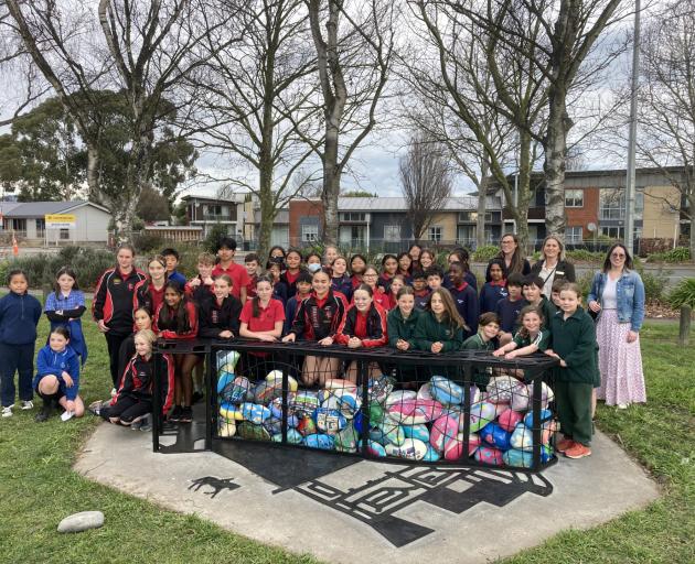 Pupils from some of the schools involved in the project and helpers celebrate the unveiling of...