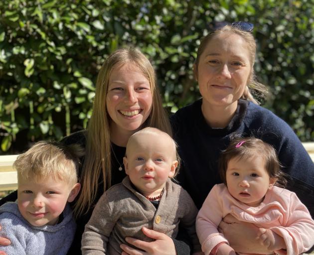 Perkins (left) and Schrader with children (from left) Ari, 3, Loki, 10 months, and Abigail, 8...