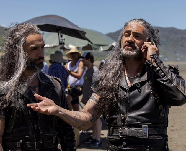 Taika Waititi talks on a phone as he stands next to Jade Daniels, his stunt double in the HBO...