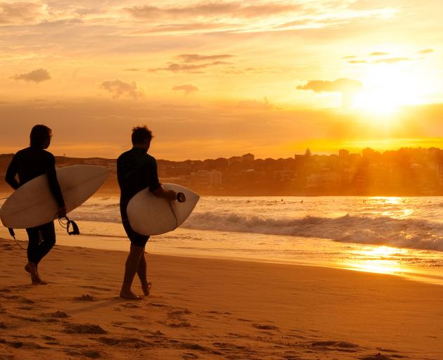 Friends heading for the surf at dawn, Bondi Beach. PHOTOS: GETTY IMAGES