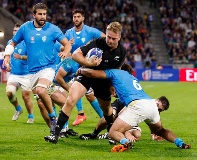 All Black captain Sam Cane is tackled by Manuel Ardao of Uruguay during a World Cup pool match...