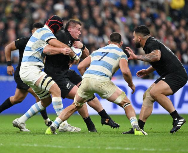 All Black Ethan de Groot (with ball) is tackled by Matias Alemanno of Argentina during the Rugby...
