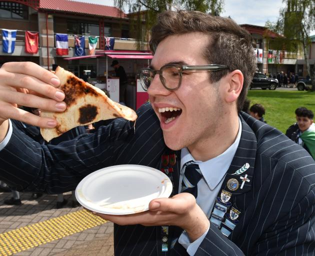 King’s High School head boy Massimo Pezzuto, who has Italian heritage, tucks into pizza during a...