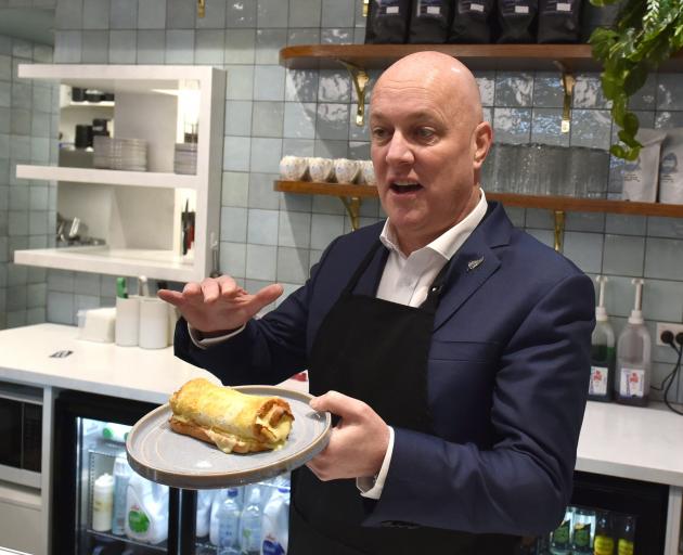 Christopher Luxon sampling a cheese roll in Invercargill. PHOTO: ODT FILES
