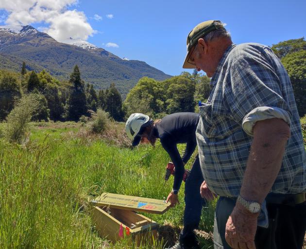 Checking one of 65 new predator traps in the Landsborough Valley on Saturday are Fulton Hogan...